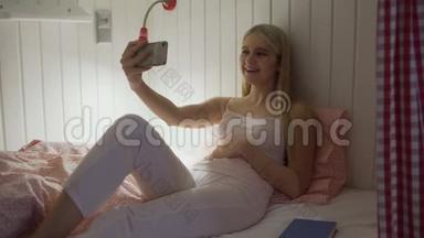 一个年轻漂亮的女人坐在宿舍房间的床上，用完智能手机睡觉