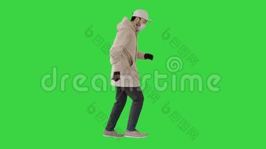 <strong>年</strong>轻人穿着户外衣服和医用<strong>口罩</strong>在绿色屏幕上慢跑，Chroma键。