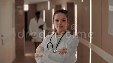 微笑女医生在医院走廊里看着摄像机