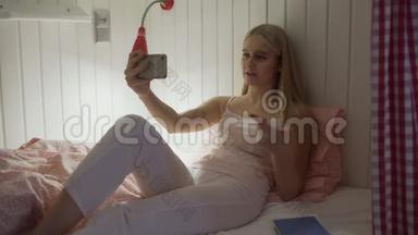 一个年轻漂亮的女人坐在<strong>宿舍</strong>房间的床<strong>上</strong>，用完智能手机睡觉