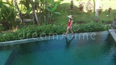 豪华异国海岛无限游泳池的高空俯视图。 女人在泳池边散步，享受丛林美景