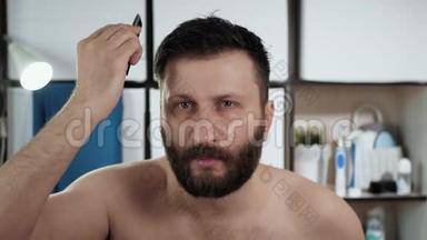 人在梳头.. 年轻漂亮的白人在浴室里梳着镜子前的头发。 卫生
