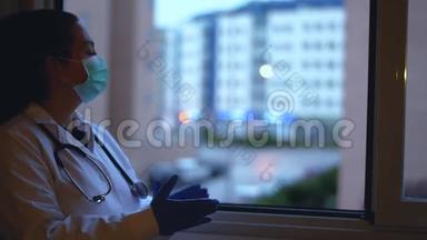 带着面具和听诊器的女医生在窗外拍手