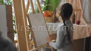 艺术工作室的<strong>老师</strong>教孩子们，坐在画架前的女孩仔细听<strong>老师</strong>的话。
