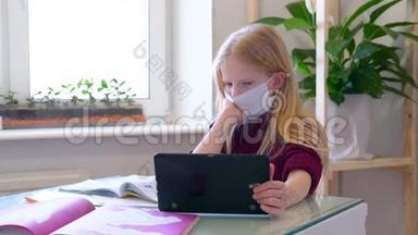 <strong>远程学习</strong>在线教育.. 带着医用口罩在家<strong>学习</strong>的生病女学生手里拿着数码平板电脑