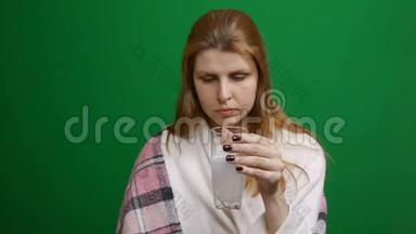 女人正在喝泡腾腾的药丸。 药丸滴下来，用气泡溶解。 红头发。 COVID泡腾片
