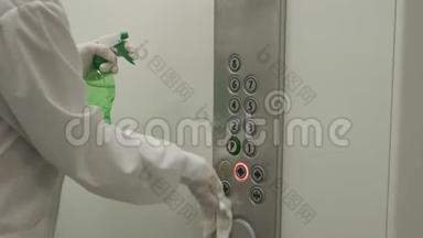 女士使用湿擦和酒精消毒喷雾清洁电梯按钮控制面板。 消毒