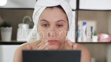 面部皮肤按摩。 有魅力的女孩在浴室用毛巾和镜子做面部按摩，在鼻子的颧骨<strong>部位</strong>