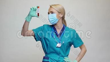 医生、护士、戴防护面罩和手套的妇女-持有COVID-19血液测试