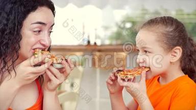 美丽的小女孩卷发和妈妈坐在餐桌旁吃意大利披萨，看着每一个人