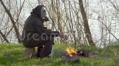 一个戴防毒面具的人在篝火旁炸香肠