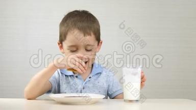 孩子喝牛奶，吃三明治.. 这个男孩吃了一个夹心巧克力糊，喝了一杯牛奶。 健康