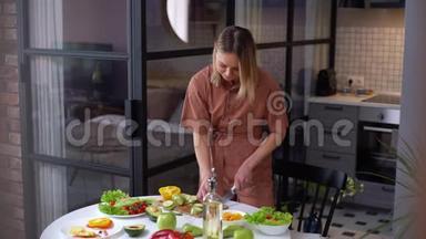 幸福的年轻女子素食者独自在家准备沙拉餐。