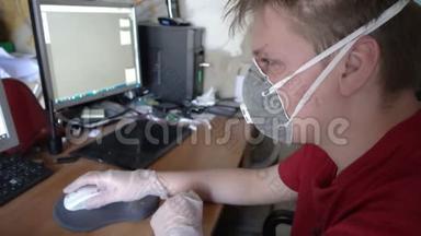 戴防护面罩和手套的年轻人因冠状病毒检疫而<strong>在家</strong>用电脑工作