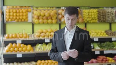 在杂货店里查看账单的白人成年人的正面表情很惊讶。 一幅严肃男人的画像