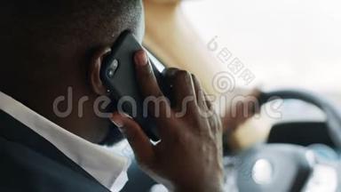 非洲男人在车上打电话的背影。 坐在方向盘后面的人