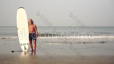 在大海的背景上有冲浪板的成熟老人