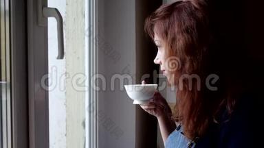 在隔离期间，年轻女子喝<strong>着</strong>咖啡<strong>看着窗外</strong>。 社会距离