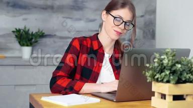 一个年轻的白人女学生在家里用笔记本电脑做功课或准备考试