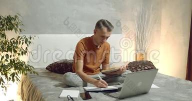年轻人在家读书，在笔记本电脑上做笔记。 网上学习
