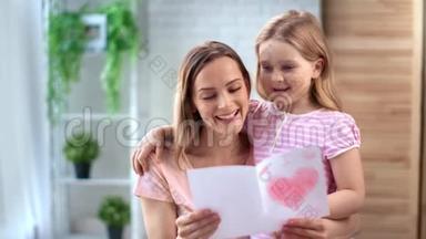 漂亮的小女孩用贺卡祝贺妈妈母亲节。 中型摄影机