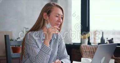 年轻健康快乐的医生女人在笔记本电脑上打视频电话到家里工作，在线咨询人们戴着口罩。