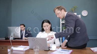 商务人士在办公室里谈论笔记本电脑