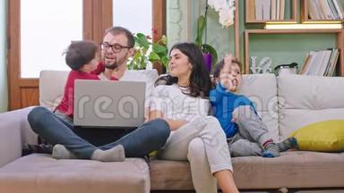 年轻漂亮的一家人坐在沙发上，呆在家里隔离，他们在一起玩聊天玩得很开心