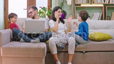 有趣的是，在家里，年轻的一家人和<strong>两个小孩子</strong>一起坐在沙发上玩，玩得很开心