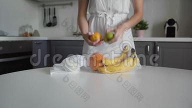 年轻的女人把水果从塑料袋移到厨房木桌上可重复使用的网袋。 零废物之家和生态袋