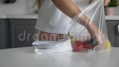 靠近的年轻女人把蔬菜从塑料袋移到厨房木桌上可重复使用的网袋。 <strong>零废物</strong>