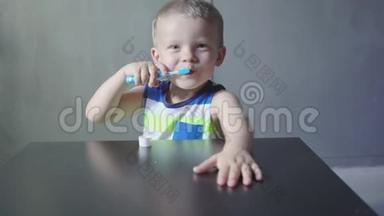 男孩在浴缸里刷牙，微笑，<strong>浅灰色背景</strong>