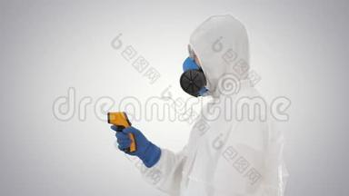 在梯度背景下穿着高温计的防护服的电晕病毒医生的温度检查。