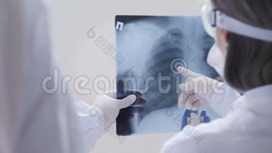 医生站在白色背景下检查X光检查一名Covid-19病人在诊所的<strong>肺炎</strong>。 冠状病毒
