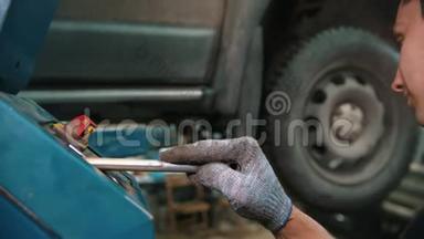 汽车修理店----维修服务结束后，青年工人将汽车吊下