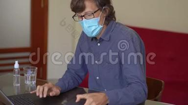 一个戴着面罩的年轻人在家中工作，进行电晕病毒自我隔离