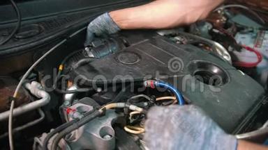 汽车修理厂-工人断开汽车引擎盖下的油门总成