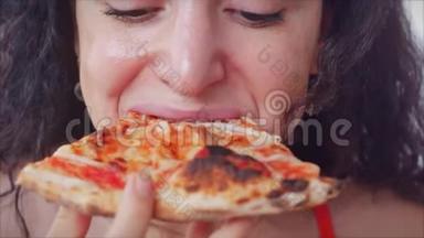 快乐放松的年轻意大利女人，穿着红色连衣裙，拿着一片馅饼，急切地吃着意大利披萨，享受着意大利披萨