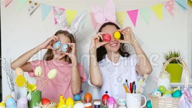妈妈和她的小女儿画鸡蛋。 为复活节做准备的幸福家庭。
