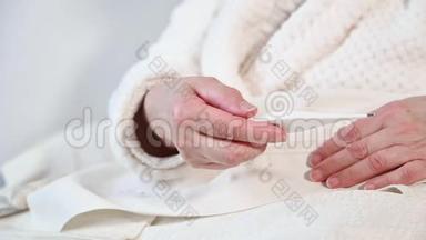 冠状病毒。 生病的老年妇女拿着体温计坐在床上，让年老的成熟妇女心烦感冒得了冠状病毒流感