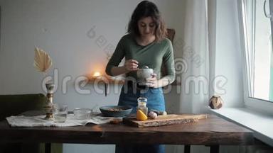 一个可爱的女孩在她的厨房把香料从灰泥到碗与鹰嘴豆煮传统鹰嘴豆