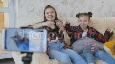 为互联网拍摄视频<strong>vlog</strong>的过程.. 两个姐妹看着相机智能手机说了些什么。