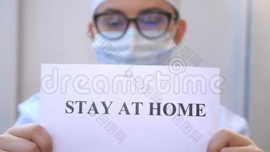 女医生正拿着一张照片，上面写着冠状病毒流行期间呆在家里。 医药展海报