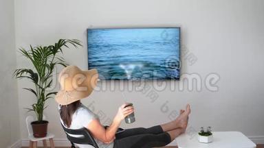 家里的女人假装在海滩上。 电视屏幕。 2020年夏季检疫旅行。 呆在家里
