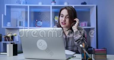认真的女学生戴着耳机在网上学习，与网络老师学习语言，看笔记本电脑，专注