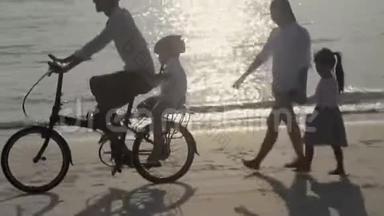 快乐的亚洲家庭，<strong>父子</strong>俩骑自行车，母女俩一起在海滩上<strong>散步</strong>度假