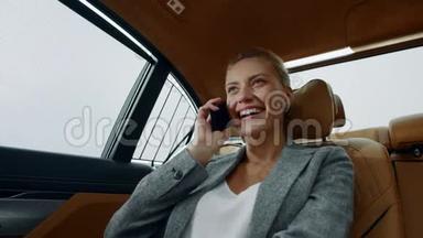 微笑的女人在出租车上打电话。 女商人在车上打电话