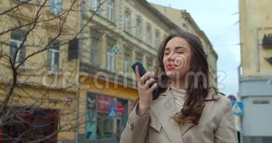 女士使用智能手机语音<strong>录音</strong>功能在线在城市街道，与移动助理交谈。 女孩使用