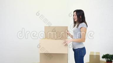 快乐满足的女人收拾纸箱，兴奋地掏出衣服。