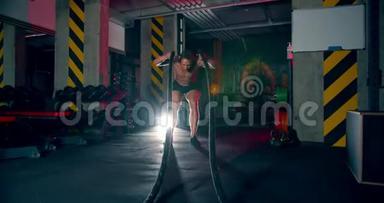 男子运动员在健身房练习战斗绳史诗般的光无<strong>摄像机</strong>运动，<strong>摄像机</strong>内绳。